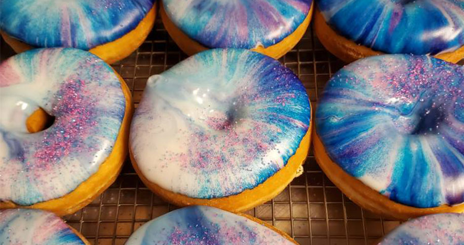 multicolor blue and purple vanilla icing doughnuts with sprinkles