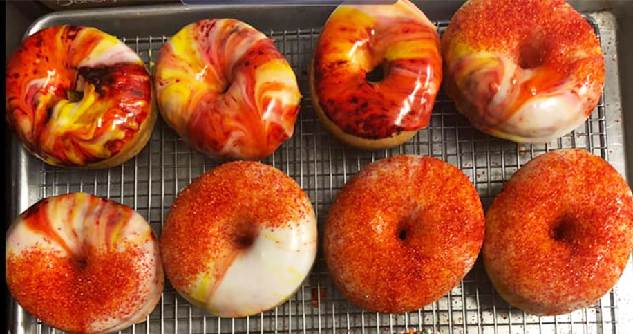 multicolor red and orange vanilla icing doughnuts with sprinkles